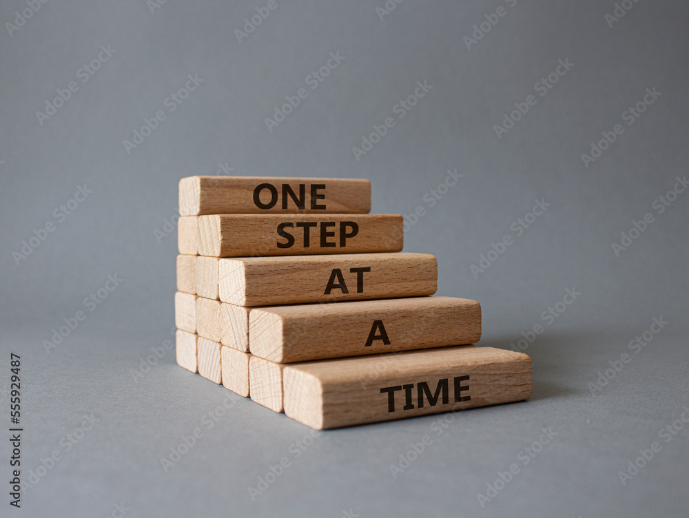 One step at a time symbol. Concept words One step at a time on wooden ...