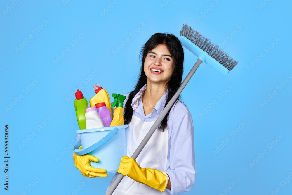 woman in gloves holding bucket of detergents and broom woman in gloves holding bucket of detergents and broom