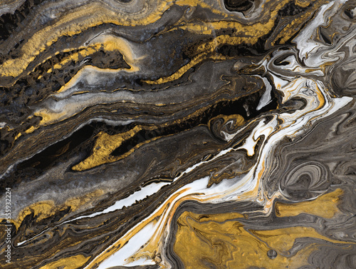 liquid acrylic fluid art close up. Gold and black liquid marble effect, modern fluid art. Drawing Creative wallpaper, beautiful design. Waves effect, trendy wash draw