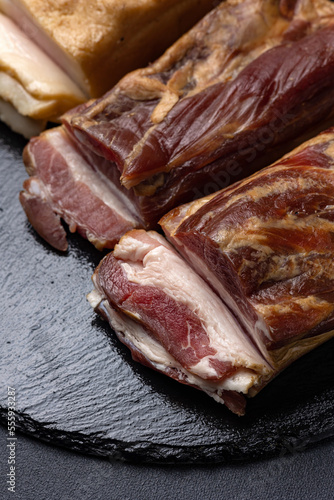 Traditional Ukrainian meat delicacies, snacks. Cold boiled pork on a dark table