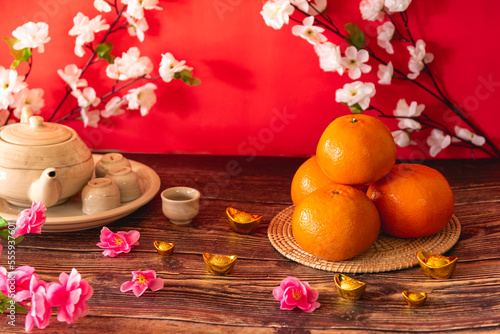 Tangerine oranges and teapot on wooden table for celebration Lunar New Year or Chinese New Year  decorate by pink and white flowers