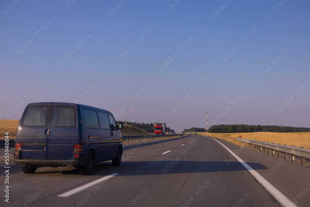 Evening view at sunset. Highway road in the countryside, roadside and asphalt Evening view at sunset. Highway road in the countryside, roadside and asphalt