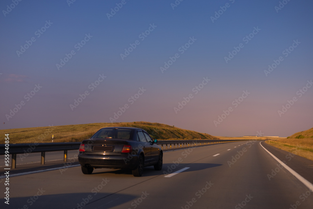 Evening view at sunset. Highway road in the countryside, roadside and asphalt