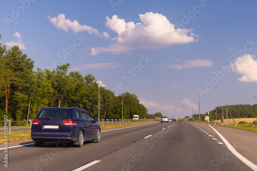 Highway wide road in the city, transport and blue sky with clouds on a summer day © Kozlik_mozlik
