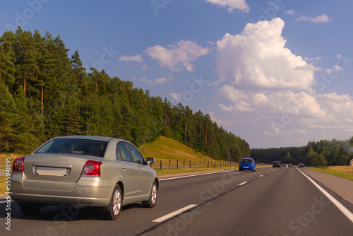 Highway wide road in the city, transport and blue sky with clouds on a summer day © Kozlik_mozlik