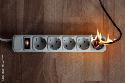 Fotografie Short circuit Extension cord power cable with a plug, butning power strip with sockets with power indicator