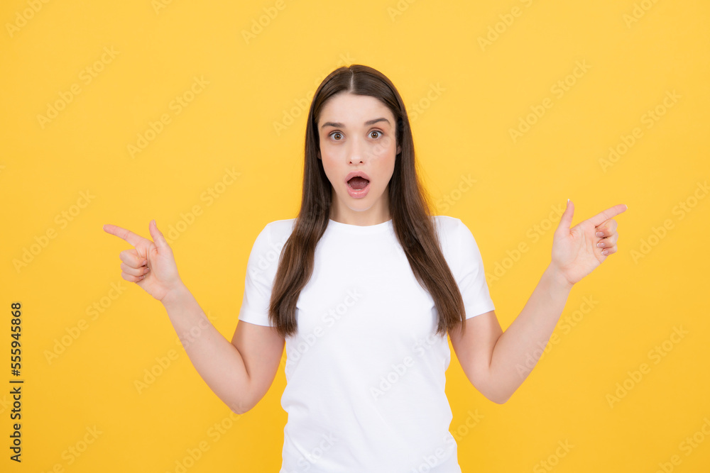 Woman point at copy space, showing copyspace pointing. Promo, girl showing advertisement content gesture, pointing with hand recommend product. Isolated yellow background. Woman point at copy space, showing copyspace pointing. Promo, girl showing advertisement content gesture, pointing with hand recommend product. Isolated yellow background.