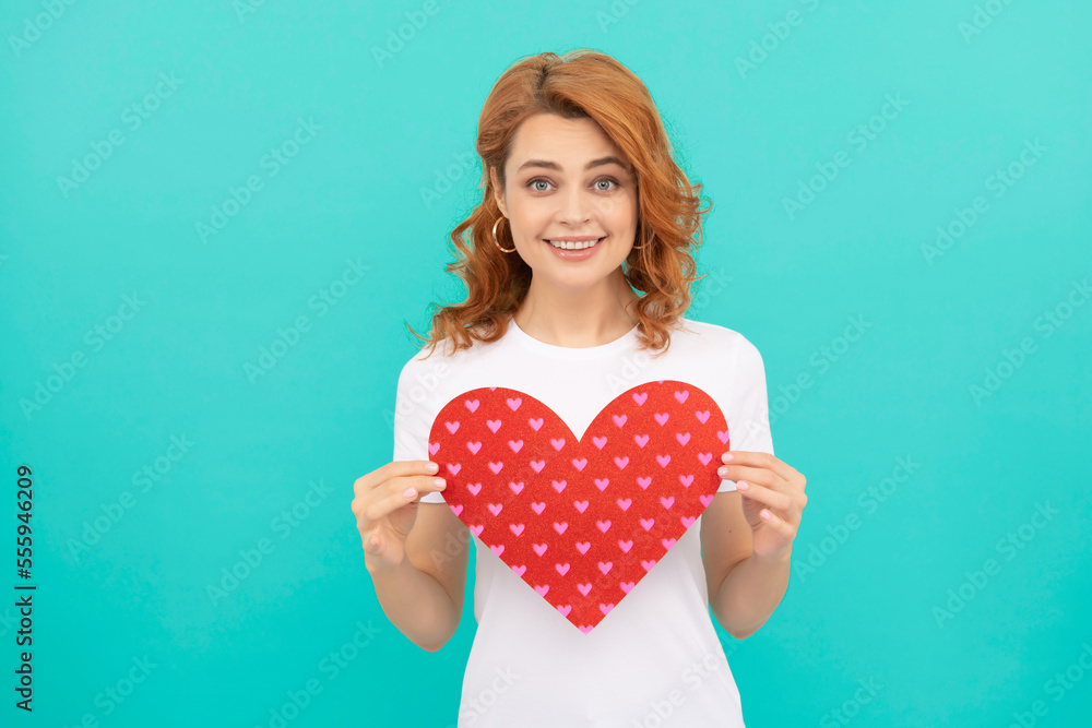 happy redhead woman hold red heart on blue background happy redhead woman hold red heart on blue background