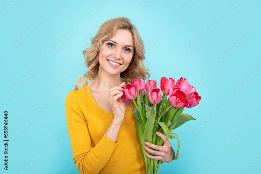 happy young woman with spring flowers on blue background happy young woman with spring flowers on blue background