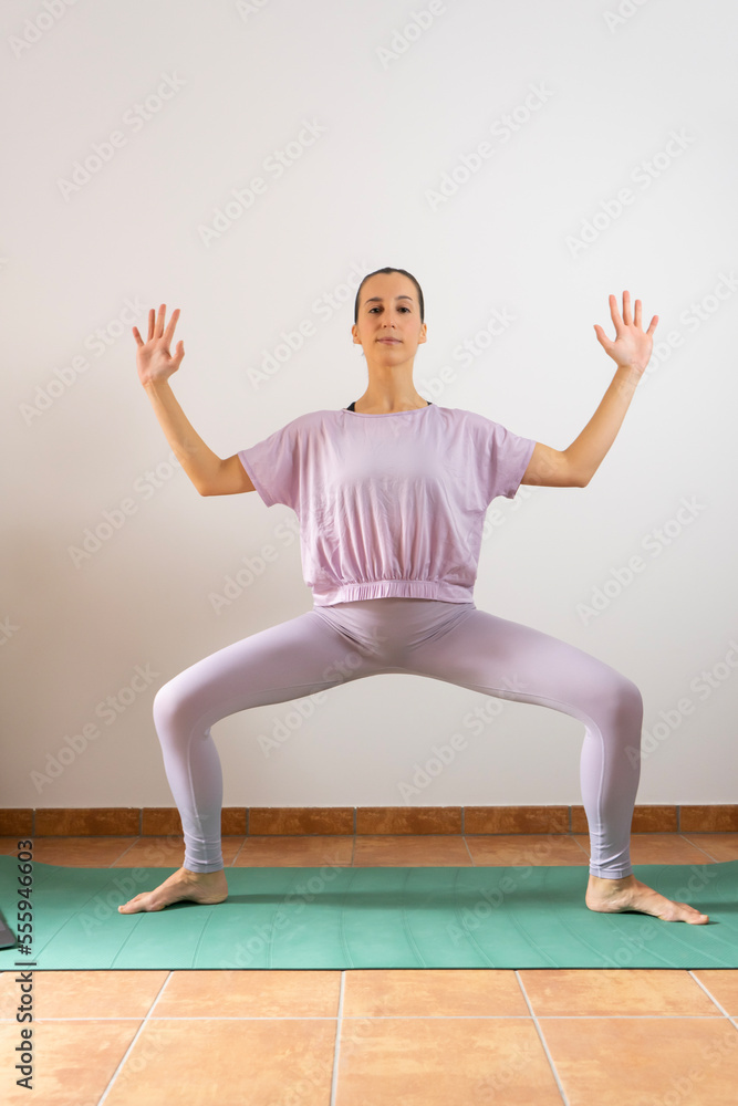 yoga. Girl doing yoga exercises at home. Goddess position	