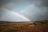 Landscape in northern Norway on a moody autumn day with a rainbow background