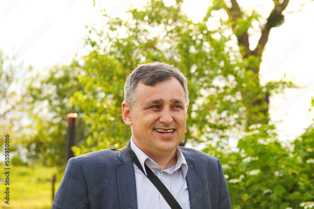Defocus handsome Mature Happy Man Smiling. Outside. Middle-aged man with a smiling expression in a close up head and shoulders portrait on nature background. Out of focus Defocus handsome Mature Happy Man Smiling. Outside. Middle-aged man with a smiling expression in a close up head and shoulders portrait on nature background. Out of focus