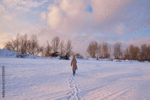 A young woman walks in the snow on a sunny frosty day, enjoying winter moments and nature, wearing winter clothes. Winter time concept, walk © Iuliia Pilipeichenko