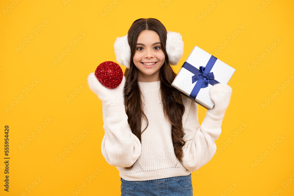 Teenager child girl holding present box isolated over yellow studio background. Present, greeting and gifting concept. New Year or Christmas holiday concept. Teenager child girl holding present box isolated over yellow studio background. Present, greeting and gifting concept. New Year or Christmas holiday concept.