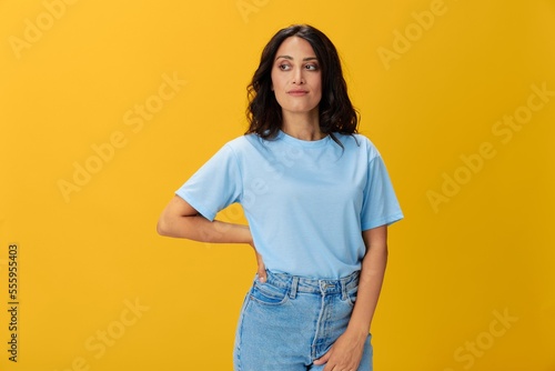 Woman signal smile with teeth emotion portrait in blue t-shirt on yellow background, hands up, surprise, lifestyle, copy space