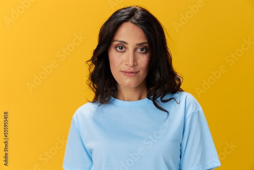 Woman signal smile with teeth emotion portrait in blue t-shirt on yellow background, hands up, surprise, lifestyle, copy space