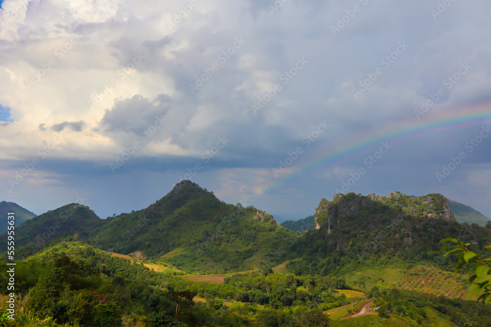 Rainbow over a green summer hills and mountains