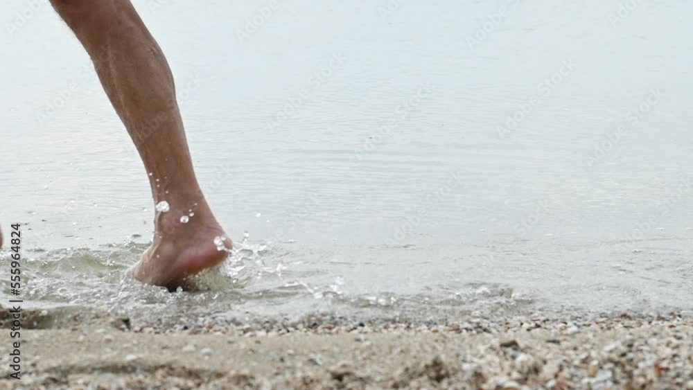 Close up of elderly man's bare feet running along the water edge of the beach. Physical activity older adults benefits Close up of elderly man's bare feet running along the water edge of the beach. Physical activity older adults benefits