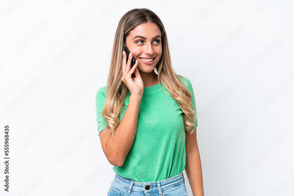 Young Uruguayan woman isolated on white background keeping a conversation with the mobile phone with someone Young Uruguayan woman isolated on white background keeping a conversation with the mobile phone with someone