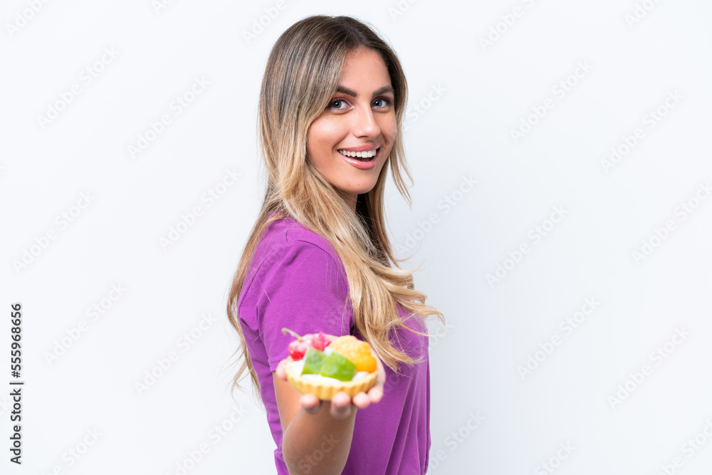 Young pretty Uruguayan woman holding a tartlet isolated on white background with happy expression Young pretty Uruguayan woman holding a tartlet isolated on white background with happy expression
