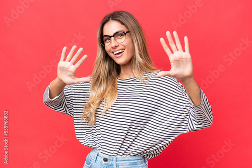 Young Uruguayan woman isolated on red background counting ten with fingers © luismolinero