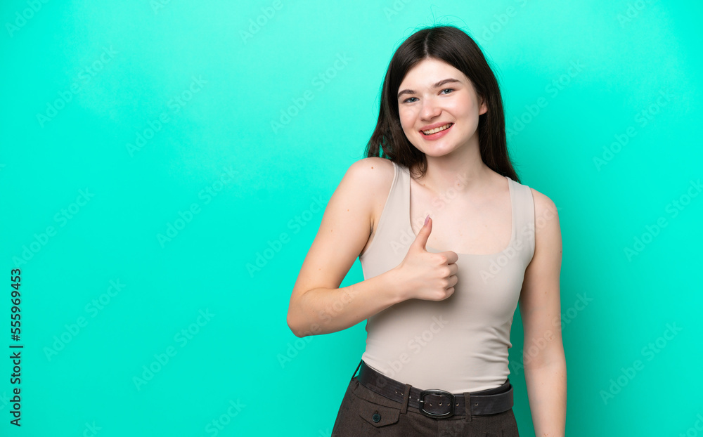 Young Russian woman isolated on green background giving a thumbs up gesture Young Russian woman isolated on green background giving a thumbs up gesture