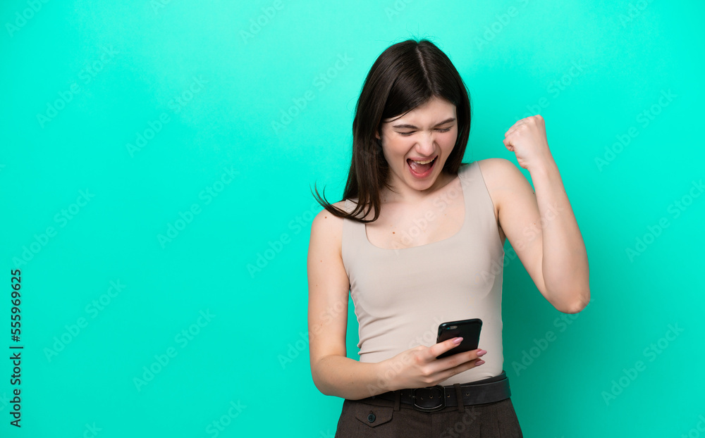 Young Russian woman isolated on green background with phone in victory position Young Russian woman isolated on green background with phone in victory position