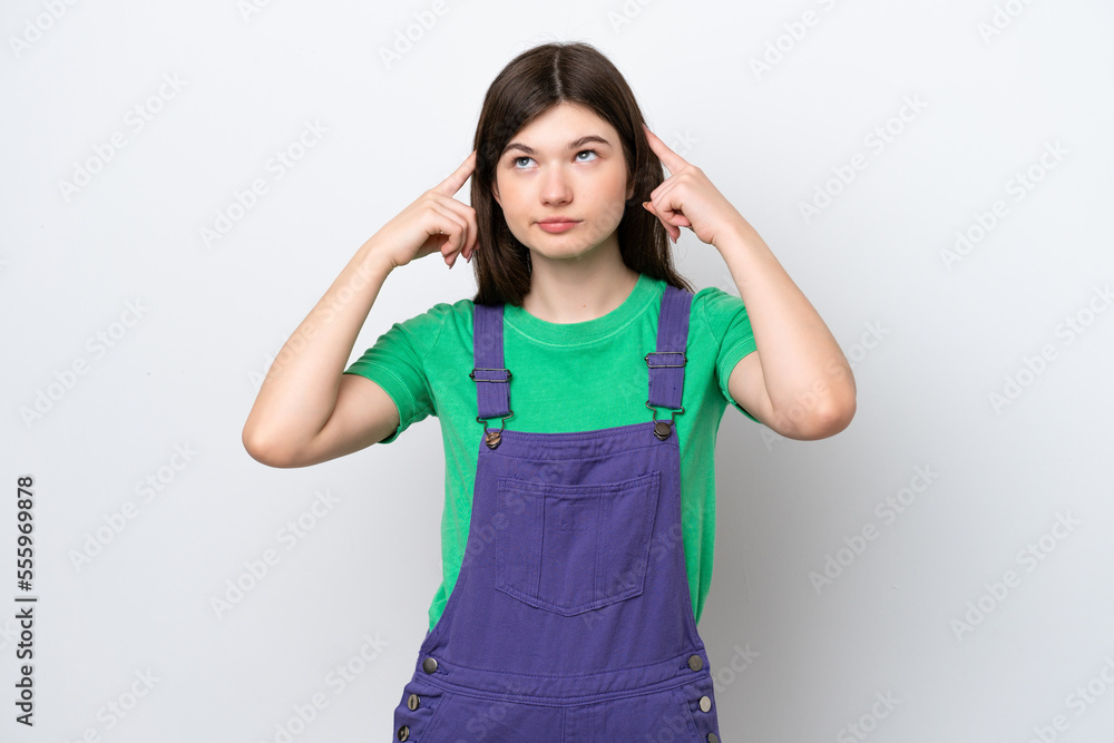 Young Russian woman isolated on blue background having doubts and thinking Young Russian woman isolated on blue background having doubts and thinking