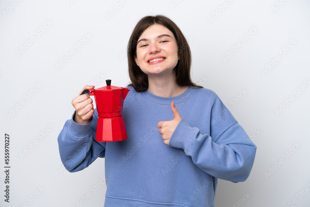Young Russian woman holding coffee pot isolated on white background giving a thumbs up gesture Young Russian woman holding coffee pot isolated on white background giving a thumbs up gesture