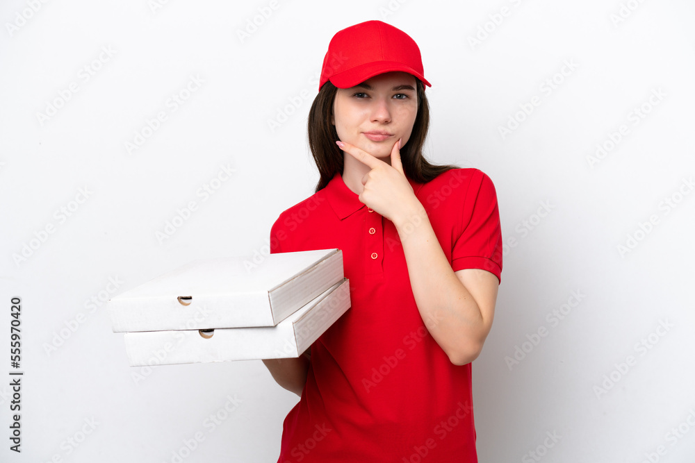 Young Russian pizza delivery picking up pizza boxes isolated on white background thinking Young Russian pizza delivery picking up pizza boxes isolated on white background thinking