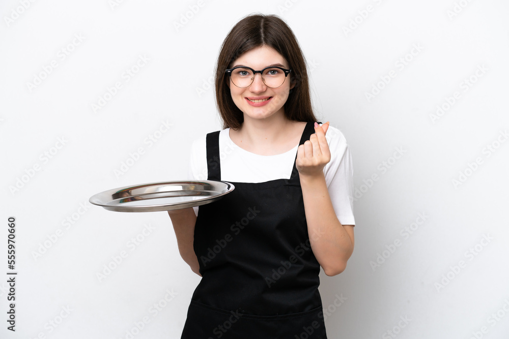 Young Russian woman chef with tray isolated on white background making money gesture Young Russian woman chef with tray isolated on white background making money gesture