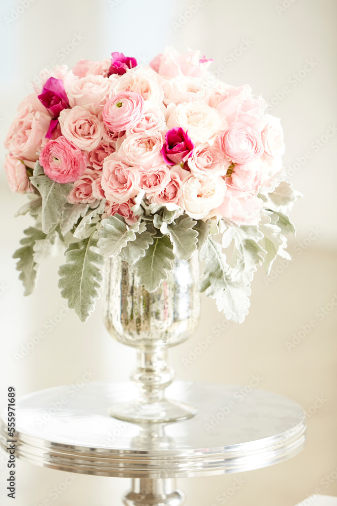 Bouquet of pink roses in silver vase on silver table, studio shot Bouquet of pink roses in silver vase on silver table, studio shot