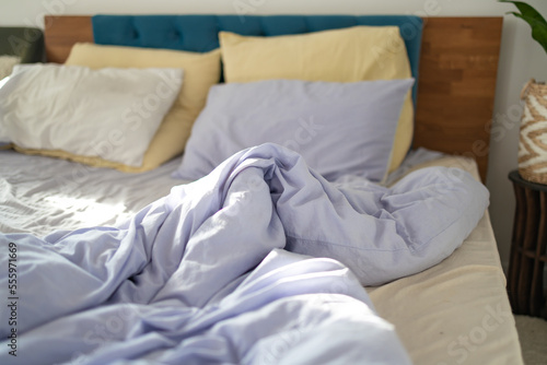 Comfort and Untidy Bed with Pillows and Duvet. The Pastel Color themed sheets and pillows were ruined after a night s sleep.