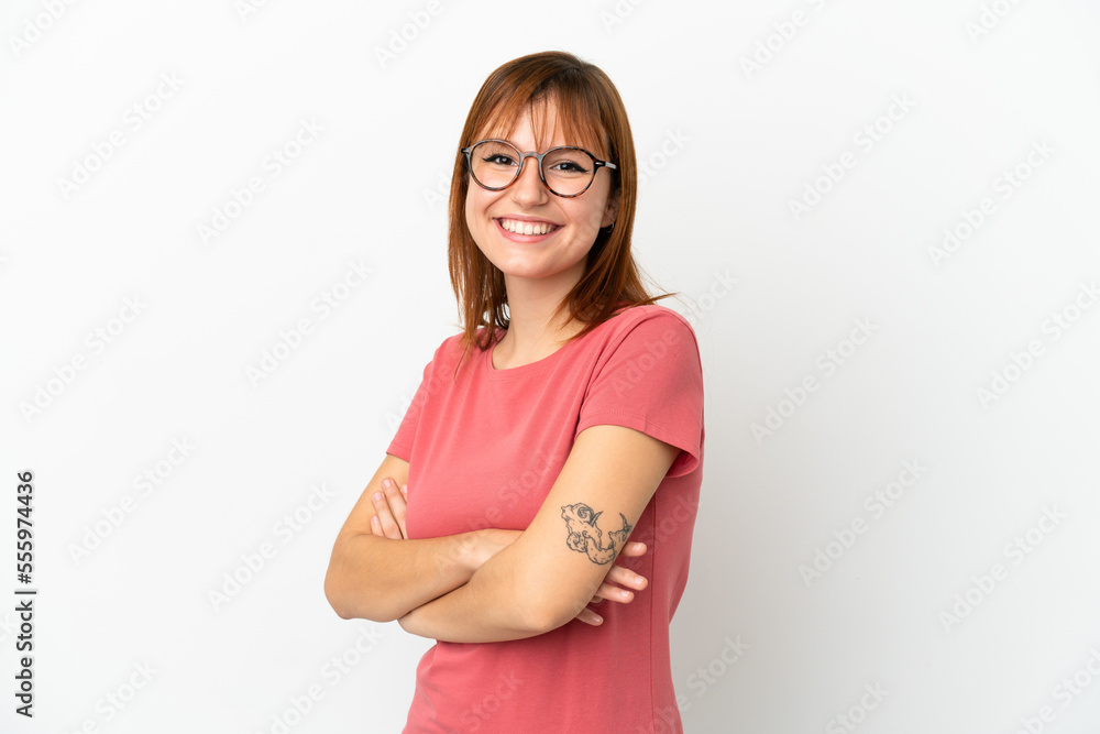 Redhead girl isolated on white background with arms crossed and looking forward Redhead girl isolated on white background with arms crossed and looking forward