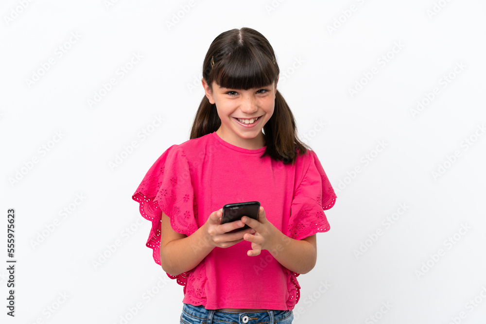 Little caucasian kid isolated on white background sending a message with the mobile Little caucasian kid isolated on white background sending a message with the mobile