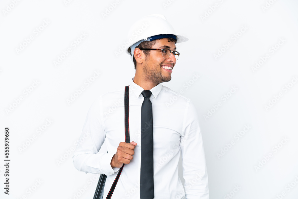 Architect brazilian man with helmet and holding blueprints looking side Architect brazilian man with helmet and holding blueprints looking side