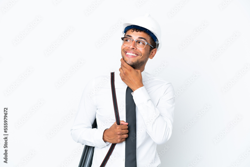 Architect brazilian man with helmet and holding blueprints looking up while smiling Architect brazilian man with helmet and holding blueprints looking up while smiling
