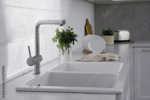 Modern sink and water tap on kitchen counter. Interior design