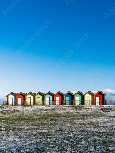 Colorful beach huts with blue sky background and frost