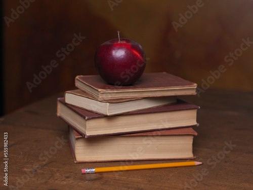 Stack of Old Books With Apple and Pencil photo