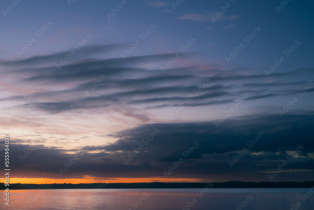 Cloudy dawn over lake in summer