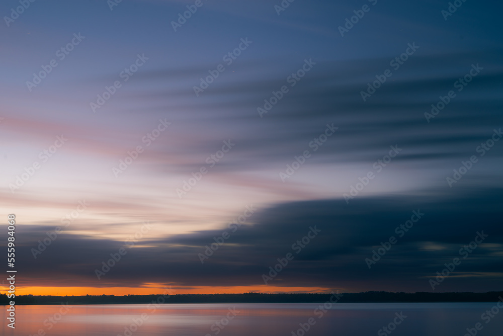 Cloudy dawn over lake in summer