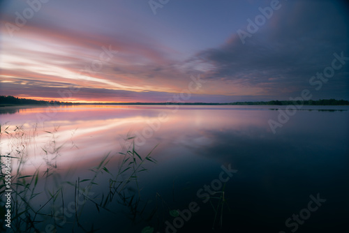 Tranquil cloudy dawn over lake in summer