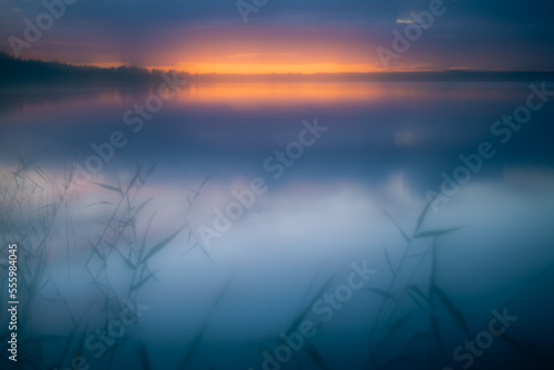 Misty dawn over lake in summer