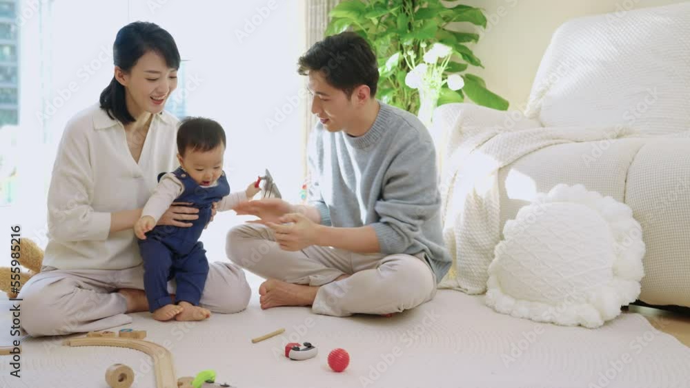 Young Chinese parents playing with their baby at home