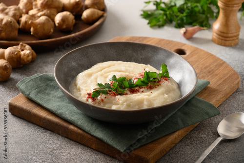 Cuadro en lienzo Jerusalem artichoke puree in plate decorated parsley on gray background