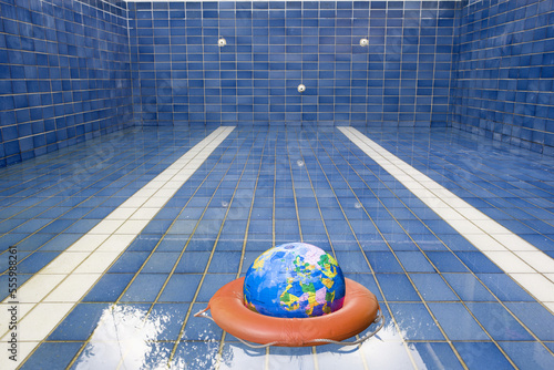 Earth and Life Preserver in Empty Swimming Pool photo