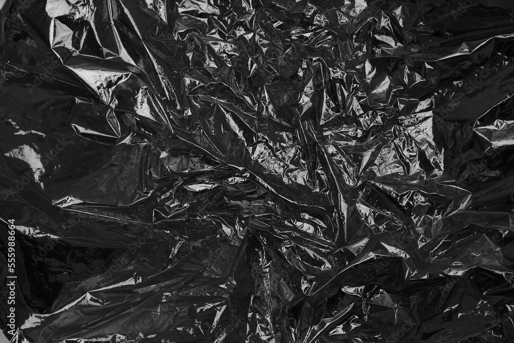 Black cellophane foil. Abstract glow texture copy space background. Black cellophane foil. Abstract glow texture copy space background.