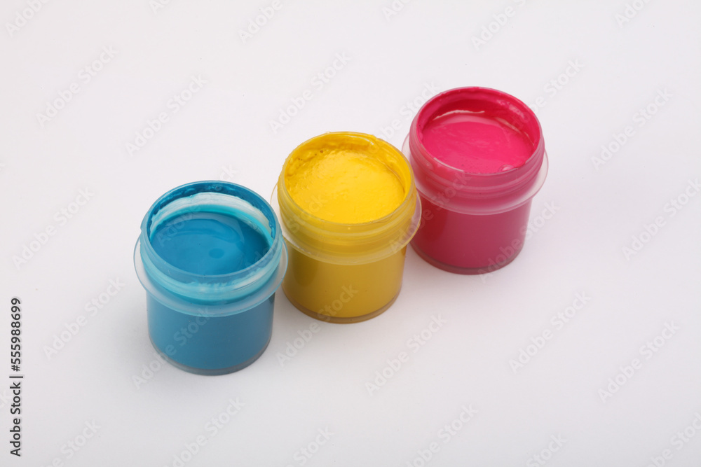 Acrylic paints in boxes on and white. Magenta, yellow blue colors. Acrylic paints in boxes on and white. Magenta, yellow blue colors.