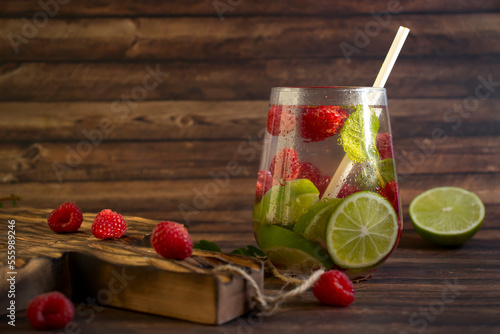 Cold water with mint, raspberry, lime on old background